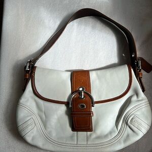Coach shoulder bag in off white leather with tan trim. Silver hardware.